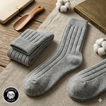 Thick ribbed gray cotton crew socks laid flat on a linen table cloth by Brooklyn Socks.